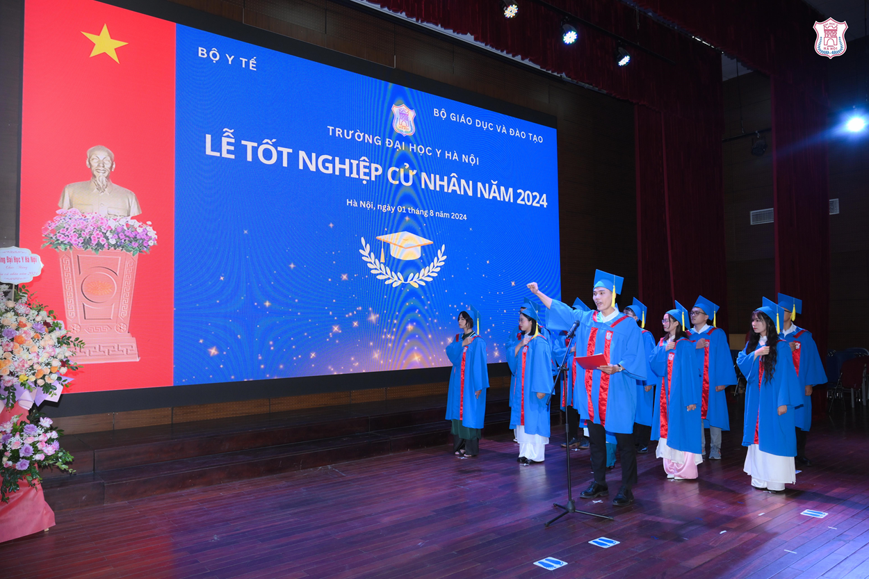 A group of people in blue gowns and hats standing on a stage

Description automatically generated